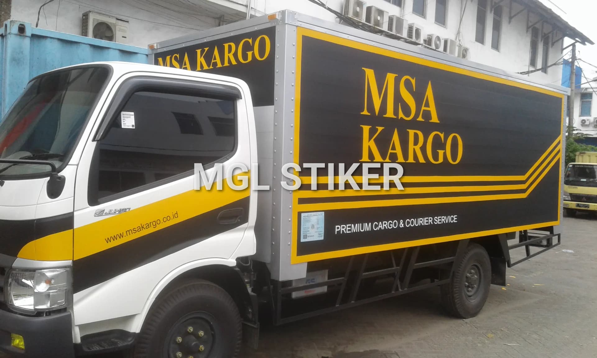 Branding mobil truk kargo MSA Kargo dengan stiker vinyl desain hitam kuning yang profesional. MGL Stiker ahli dalam jasa branding dan pemasangan stiker pada kendaraan.
