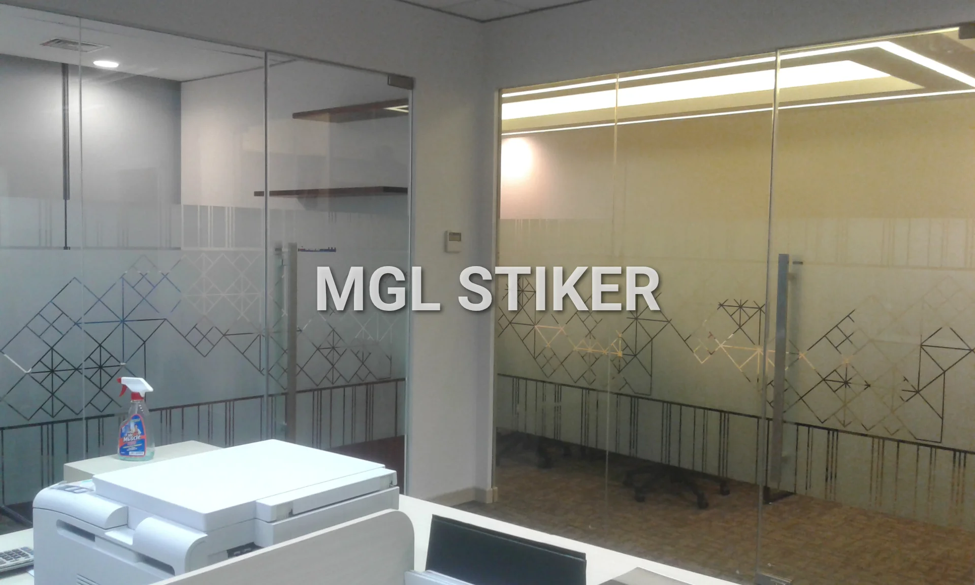 Aplikasi Sticker Sandblast motif geometris yang dihasilkan melalui Cutting Sticker pada dua partisi kaca kantor modern. Desain unik ini menambah estetika sekaligus privasi. MGL Stiker menyediakan solusi sticker sandblast dan cutting sticker untuk ruang kerja Anda.